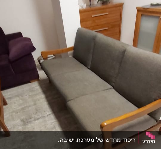 ספה אפורה עם ריפוד מרופד על שטיח אפור